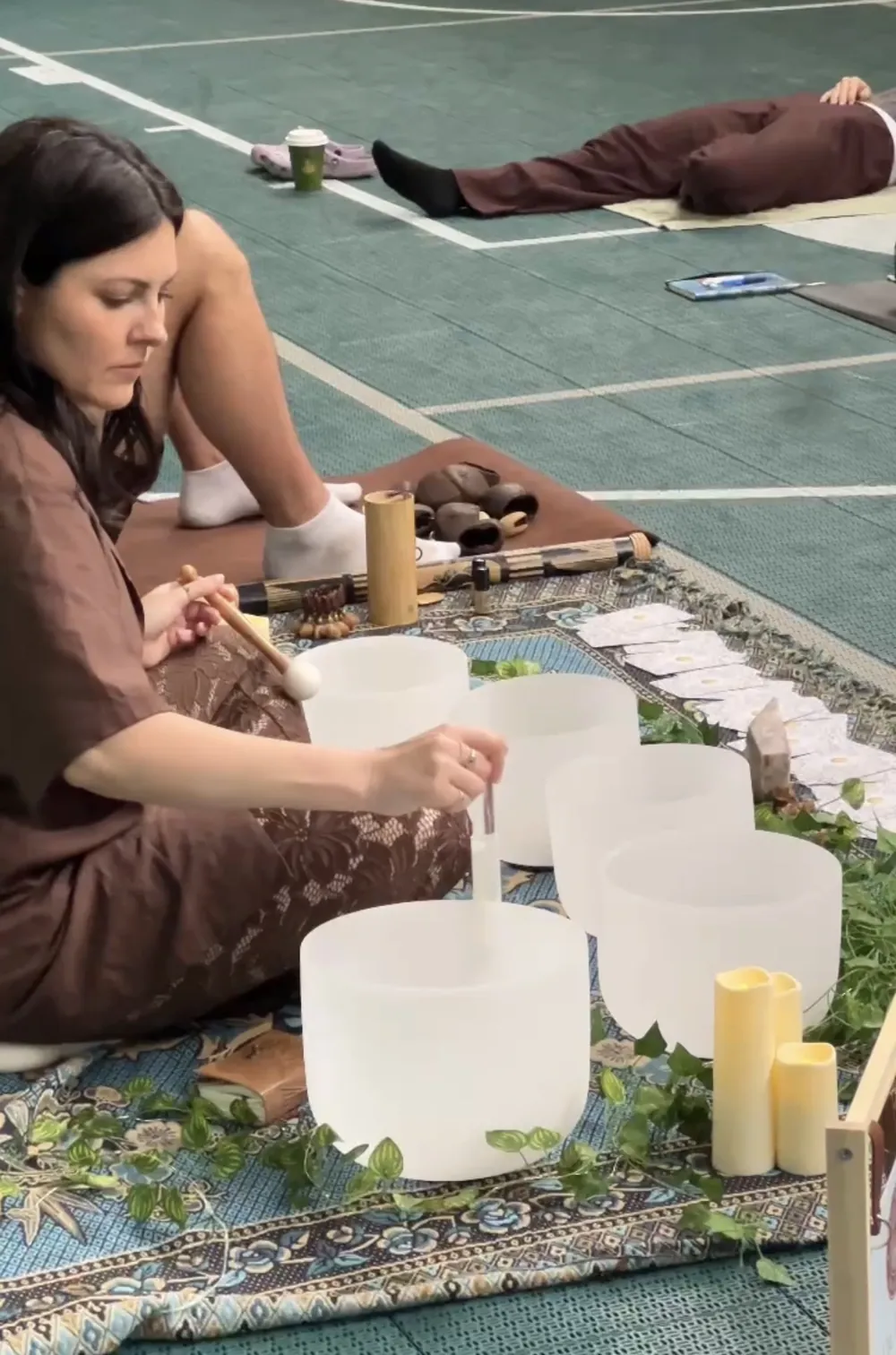 Steph playing crystal singing bowls during a group sound bath at Ark Sports Club