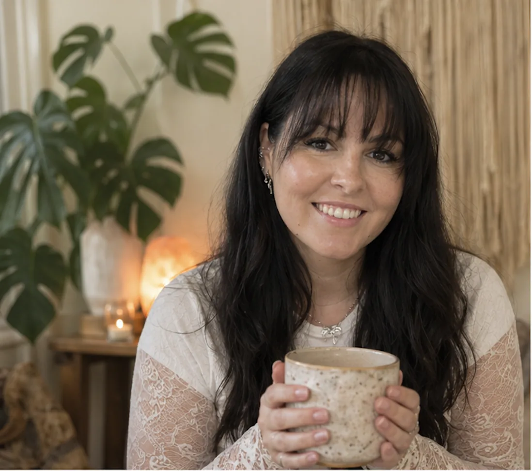 Steph, founder of The Inner Blooming, holding a cup of tea